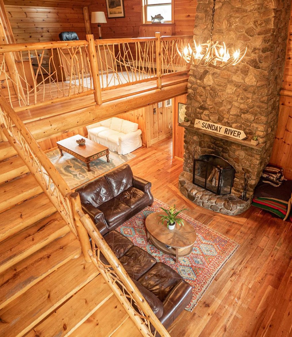 A wooden lodge with warm light as seen from the staircase.