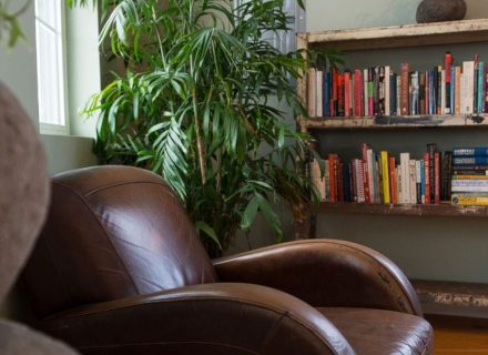 A brown leather chair in a cozy book-filled living room.