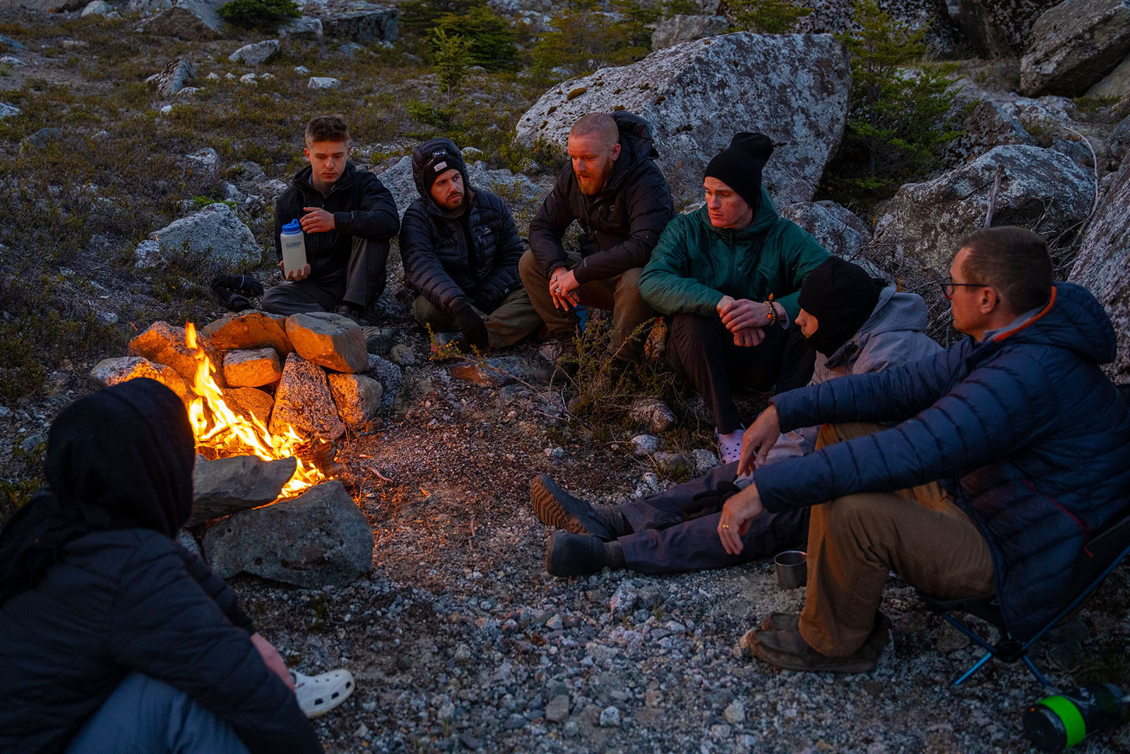 At dusk, young men sit in front of a fire and talk about recovery and A A.